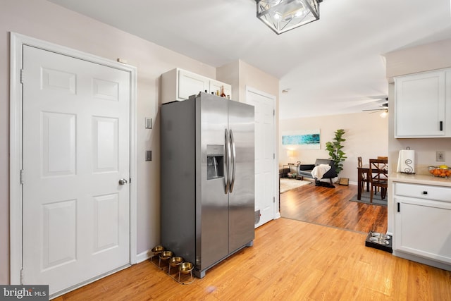 kitchen with white cabinetry, stainless steel refrigerator with ice dispenser, ceiling fan, and light wood-type flooring