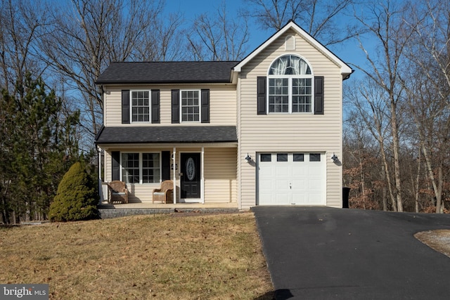 view of front property with a garage, covered porch, and a front yard