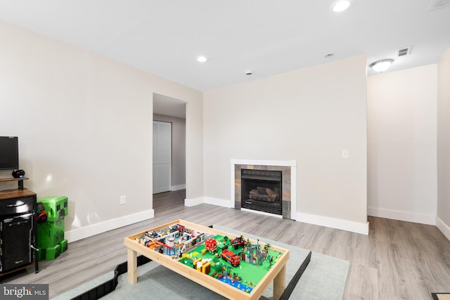 recreation room featuring hardwood / wood-style flooring and a tile fireplace