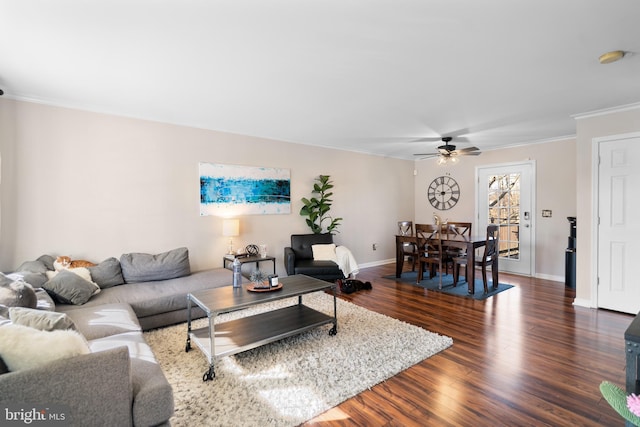 living room with dark wood-type flooring, ceiling fan, and ornamental molding