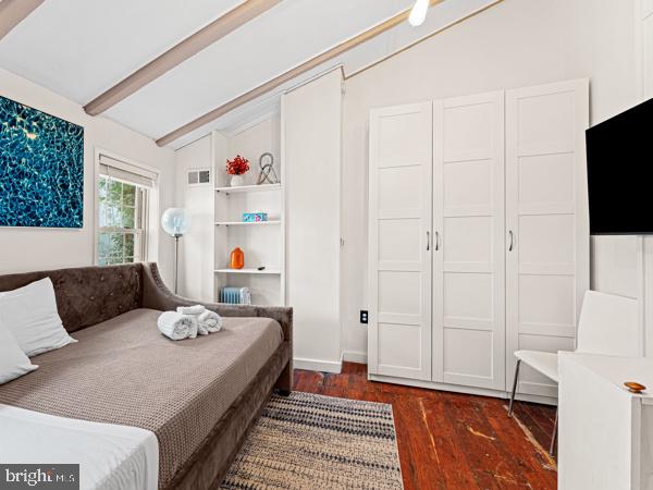 bedroom with vaulted ceiling with beams and dark hardwood / wood-style floors