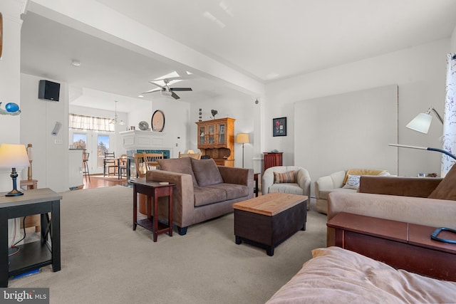 carpeted living room featuring beamed ceiling and ceiling fan