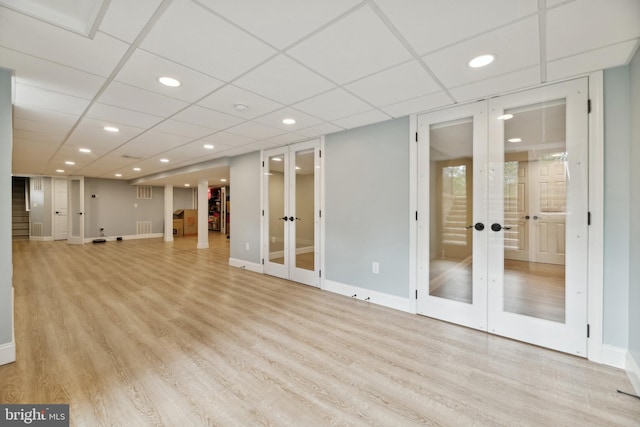 interior space with french doors, a drop ceiling, and light hardwood / wood-style flooring