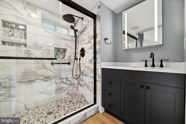 bathroom featuring hardwood / wood-style floors, vanity, and a shower with shower door