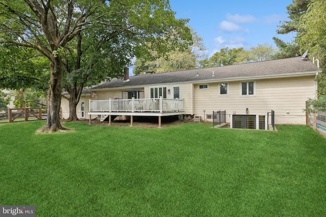 back of house featuring a lawn and a deck