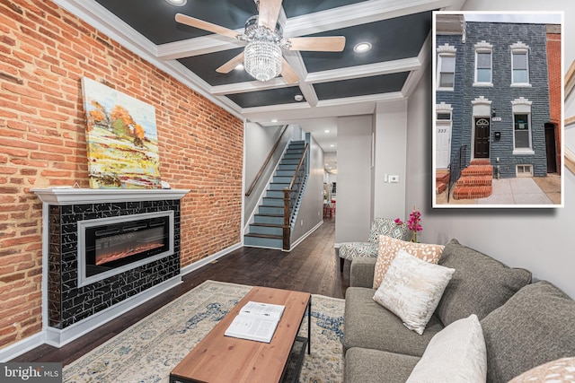 living room with brick wall, ceiling fan, crown molding, dark hardwood / wood-style floors, and a tiled fireplace