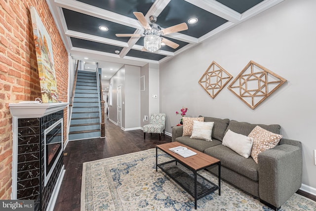 living room with dark hardwood / wood-style flooring, ornamental molding, and coffered ceiling