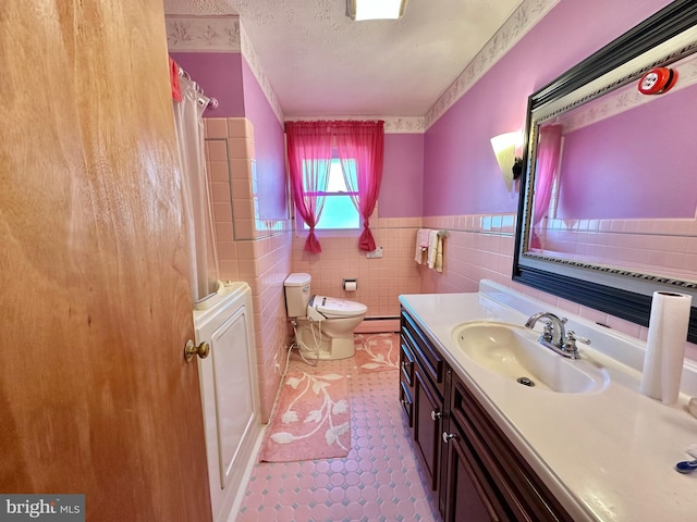 bathroom featuring a shower with curtain, vanity, baseboard heating, tile walls, and toilet