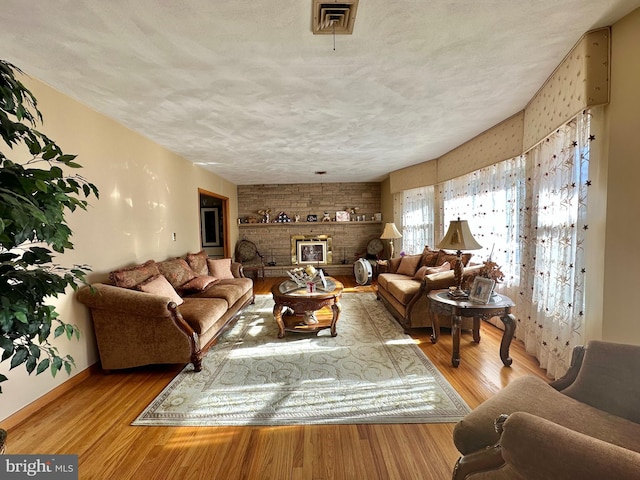 living room with light wood-type flooring and a textured ceiling