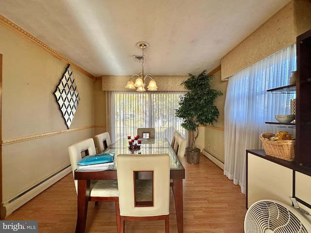 dining area featuring hardwood / wood-style flooring, an inviting chandelier, and a baseboard heating unit