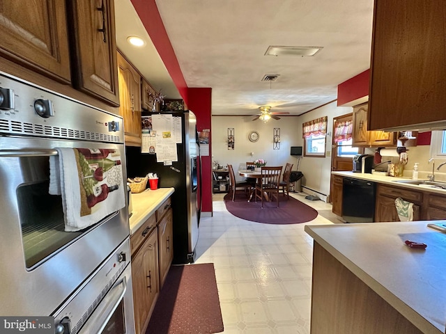 kitchen featuring ceiling fan, sink, stainless steel appliances, and a baseboard heating unit