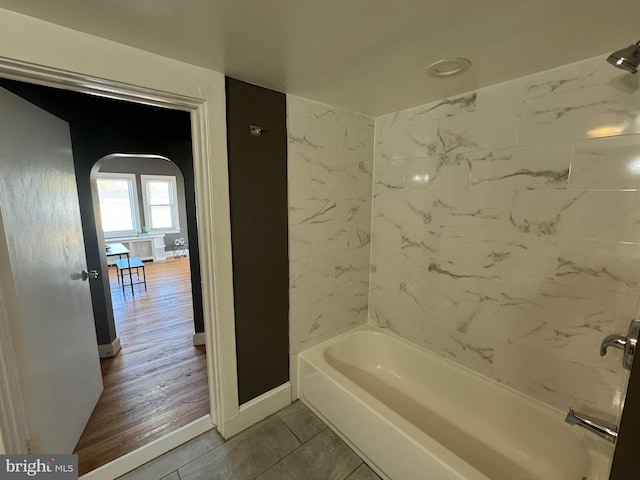 bathroom with hardwood / wood-style floors and tiled shower / bath combo