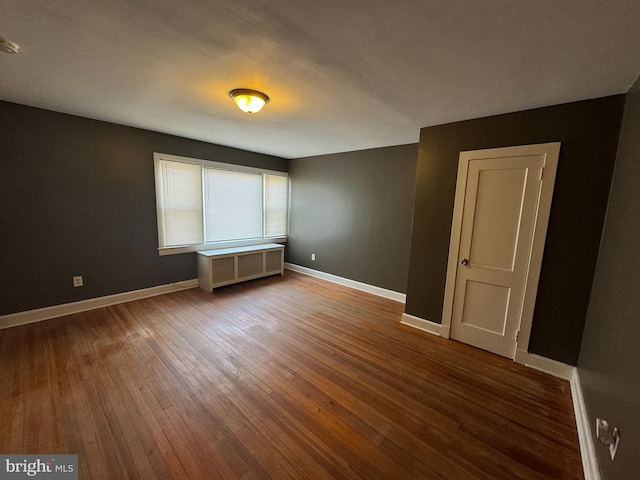 empty room featuring hardwood / wood-style floors and radiator