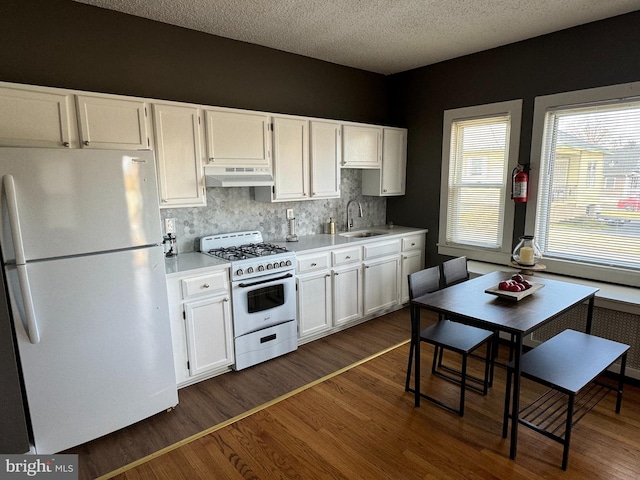 kitchen featuring white appliances, dark hardwood / wood-style floors, white cabinetry, and sink