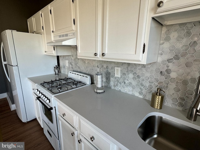 kitchen featuring dark wood-type flooring, white cabinets, sink, decorative backsplash, and gas range gas stove