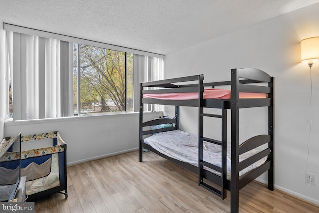 bedroom with light hardwood / wood-style floors and a textured ceiling