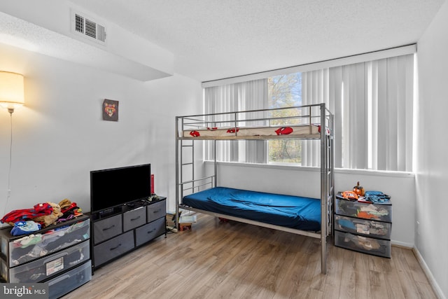 bedroom featuring a textured ceiling and light wood-type flooring