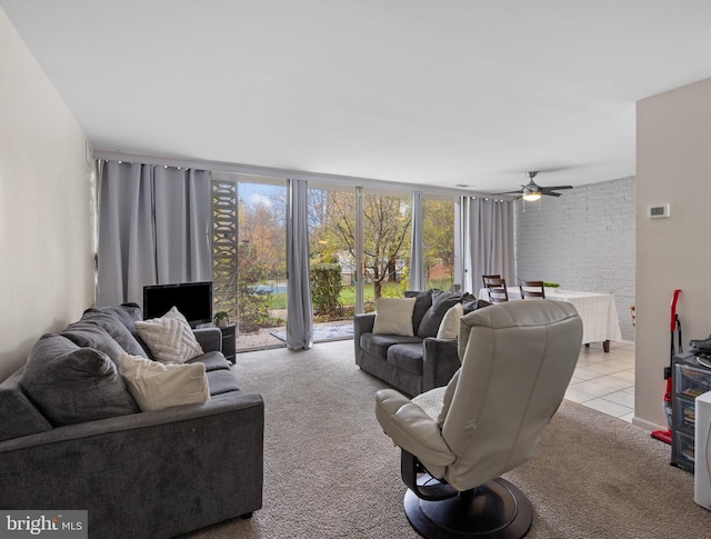 living room featuring ceiling fan, light colored carpet, and brick wall