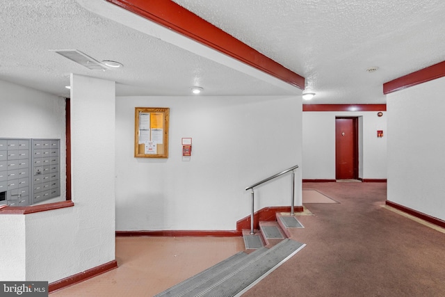 hall with carpet flooring, mail boxes, and a textured ceiling