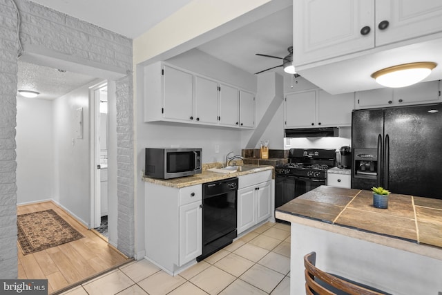 kitchen with ceiling fan, sink, light hardwood / wood-style floors, white cabinets, and black appliances