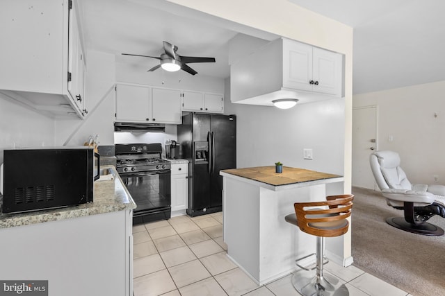 kitchen featuring ceiling fan, exhaust hood, black appliances, white cabinetry, and light tile patterned flooring