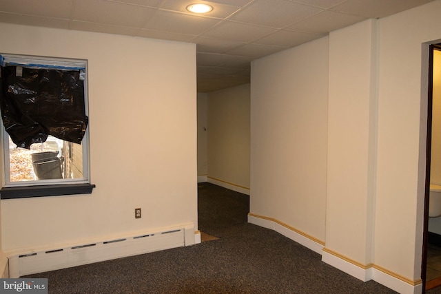 unfurnished room with a drop ceiling, dark carpet, and baseboard heating