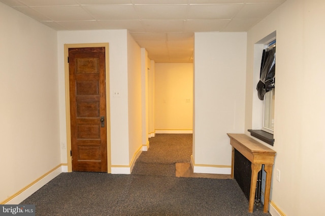 hallway featuring a paneled ceiling and carpet floors