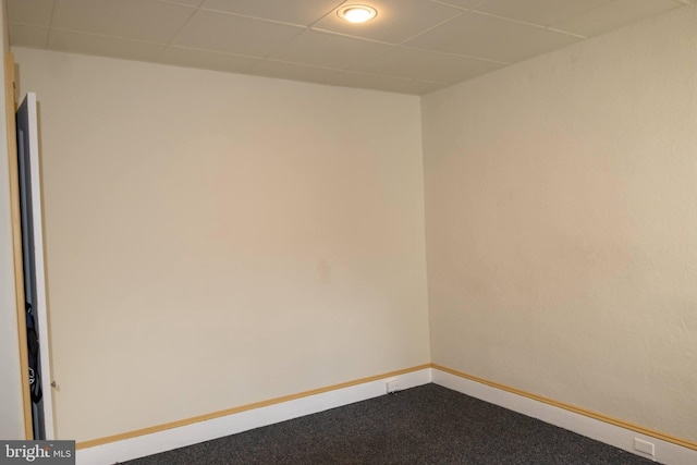 empty room featuring carpet flooring and a drop ceiling