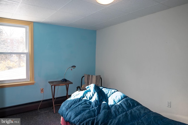 bedroom featuring carpet, a paneled ceiling, and a baseboard heating unit