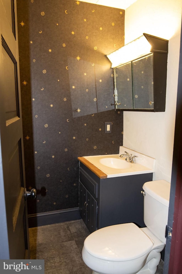 bathroom with tile patterned flooring, vanity, and toilet