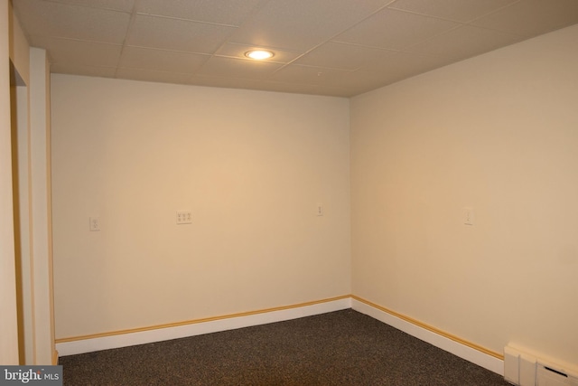 spare room with a drop ceiling, carpet floors, and baseboard heating