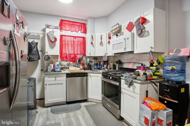 kitchen featuring light stone countertops, tasteful backsplash, stainless steel appliances, light hardwood / wood-style flooring, and white cabinetry