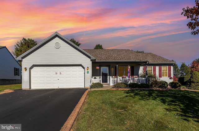 ranch-style home featuring a lawn, a porch, and a garage