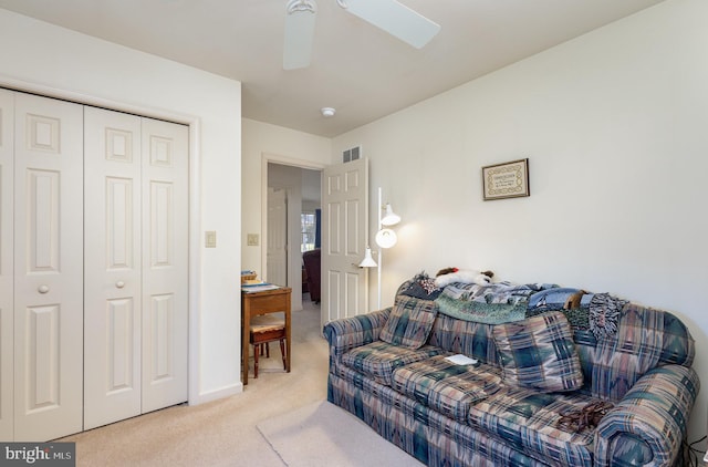 carpeted living room with ceiling fan