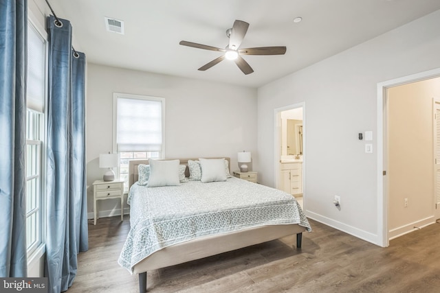 bedroom featuring sink, hardwood / wood-style flooring, ensuite bath, and ceiling fan