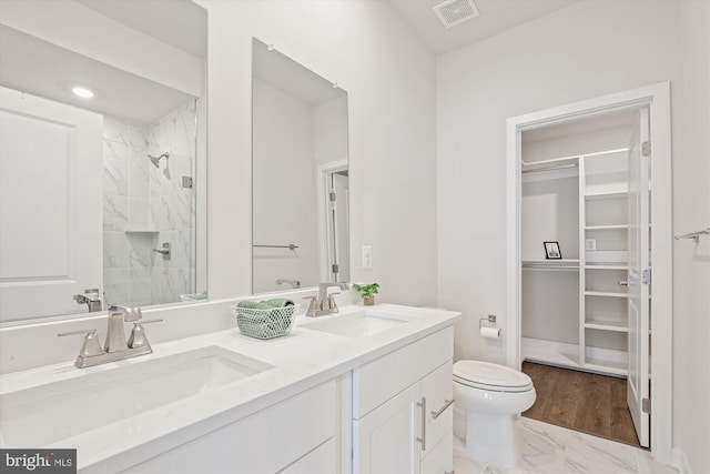 6832 General Davis NW, Washington, DC 20012 - bathroom with double vanity, toilet, a walk in closet, tiled shower, and marble finish flooring