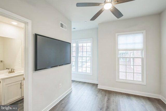 unfurnished living room with sink, ceiling fan, and dark hardwood / wood-style floors