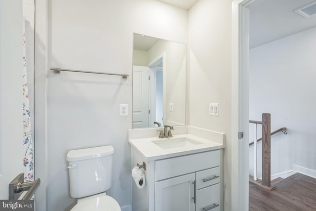 bathroom featuring wood-type flooring, toilet, and vanity