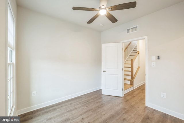 empty room with ceiling fan and light hardwood / wood-style flooring