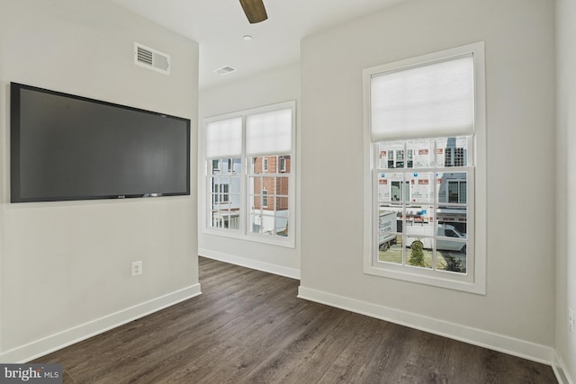 unfurnished room featuring ceiling fan and dark wood-type flooring