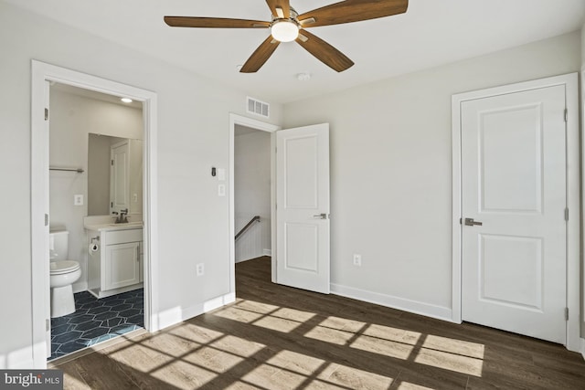 unfurnished bedroom with ceiling fan, sink, dark hardwood / wood-style floors, and ensuite bathroom