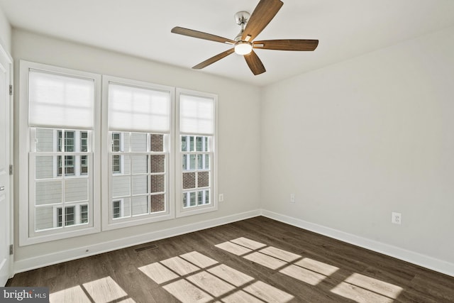 spare room with ceiling fan and dark hardwood / wood-style flooring