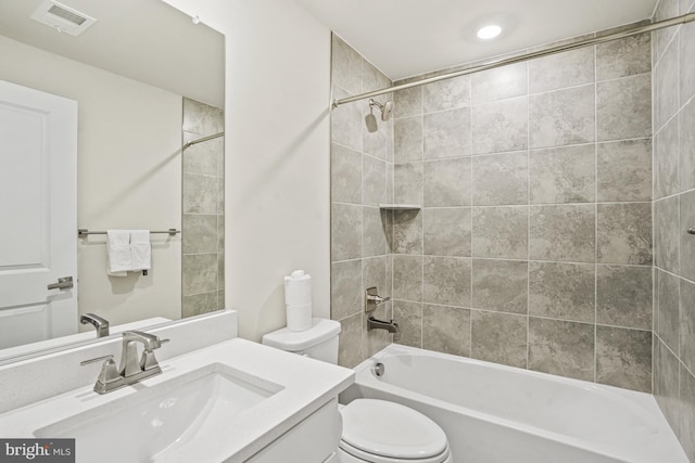 full bathroom with tiled shower / bath combo, toilet, and vanity