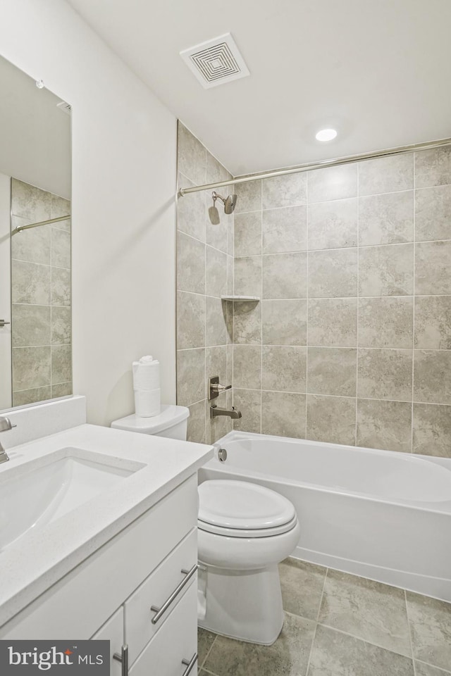 full bathroom with tiled shower / bath combo, toilet, and vanity