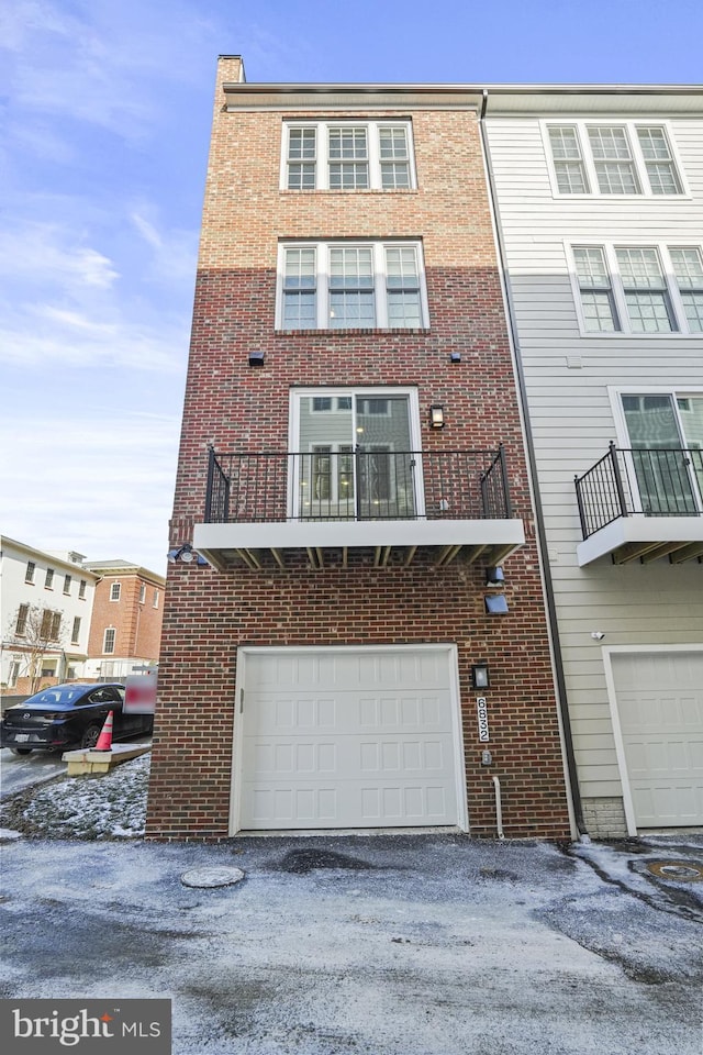 townhome / multi-family property featuring a balcony and a garage