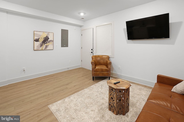 living area with electric panel and light hardwood / wood-style floors