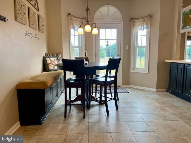 tiled dining space with an inviting chandelier