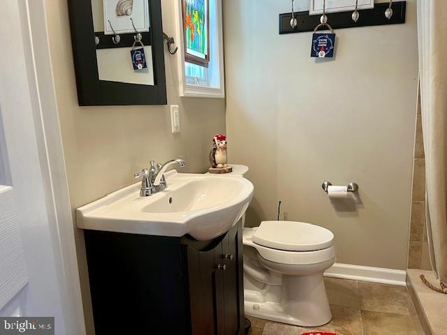 bathroom featuring tile patterned floors, vanity, curtained shower, and toilet