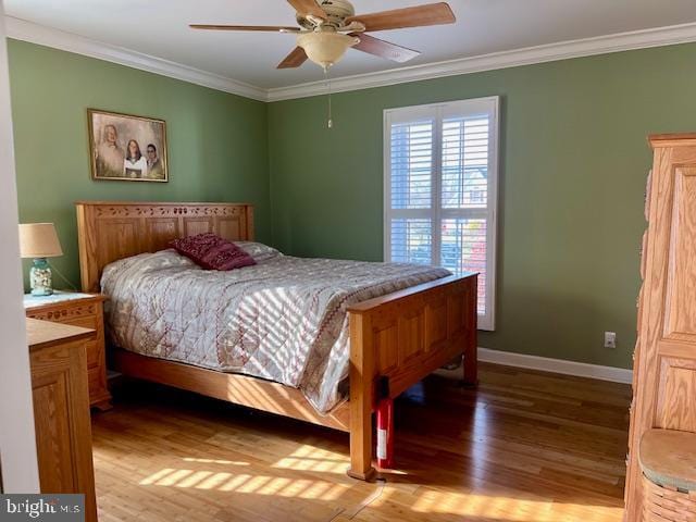 bedroom with ceiling fan, crown molding, and light hardwood / wood-style flooring