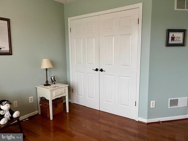 bedroom featuring a closet and dark wood-type flooring